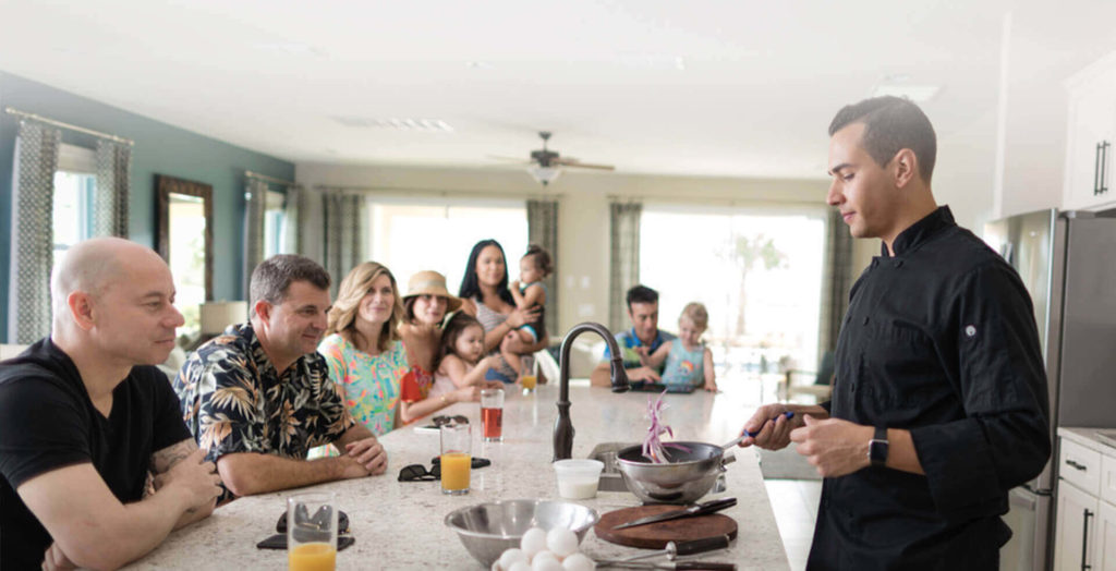 Family watches an expert chef cook in their Encore Resort home.