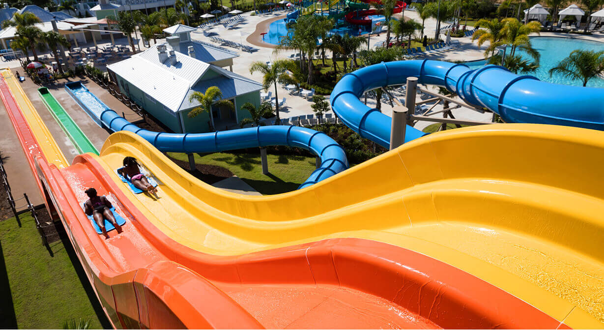 Dos personas se suben a los toboganes de agua Wave Racer en Encore Resort