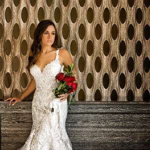 girl with brown hair in a white dress holding red roses