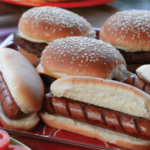 Grilled hot dogs and hamburgers on a plate.