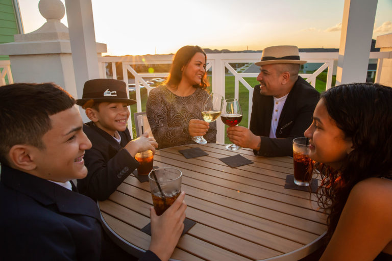 Eine fünfköpfige Familie sitzt mit Getränken an der Encore Clubhaus des Resorts.