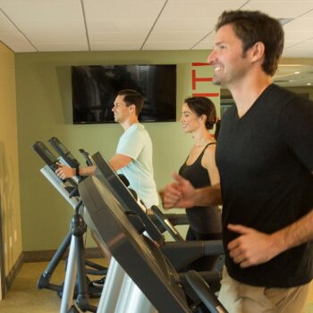 Encore Resort guests running on the Clubhouse Fitness Room’s treadmills.