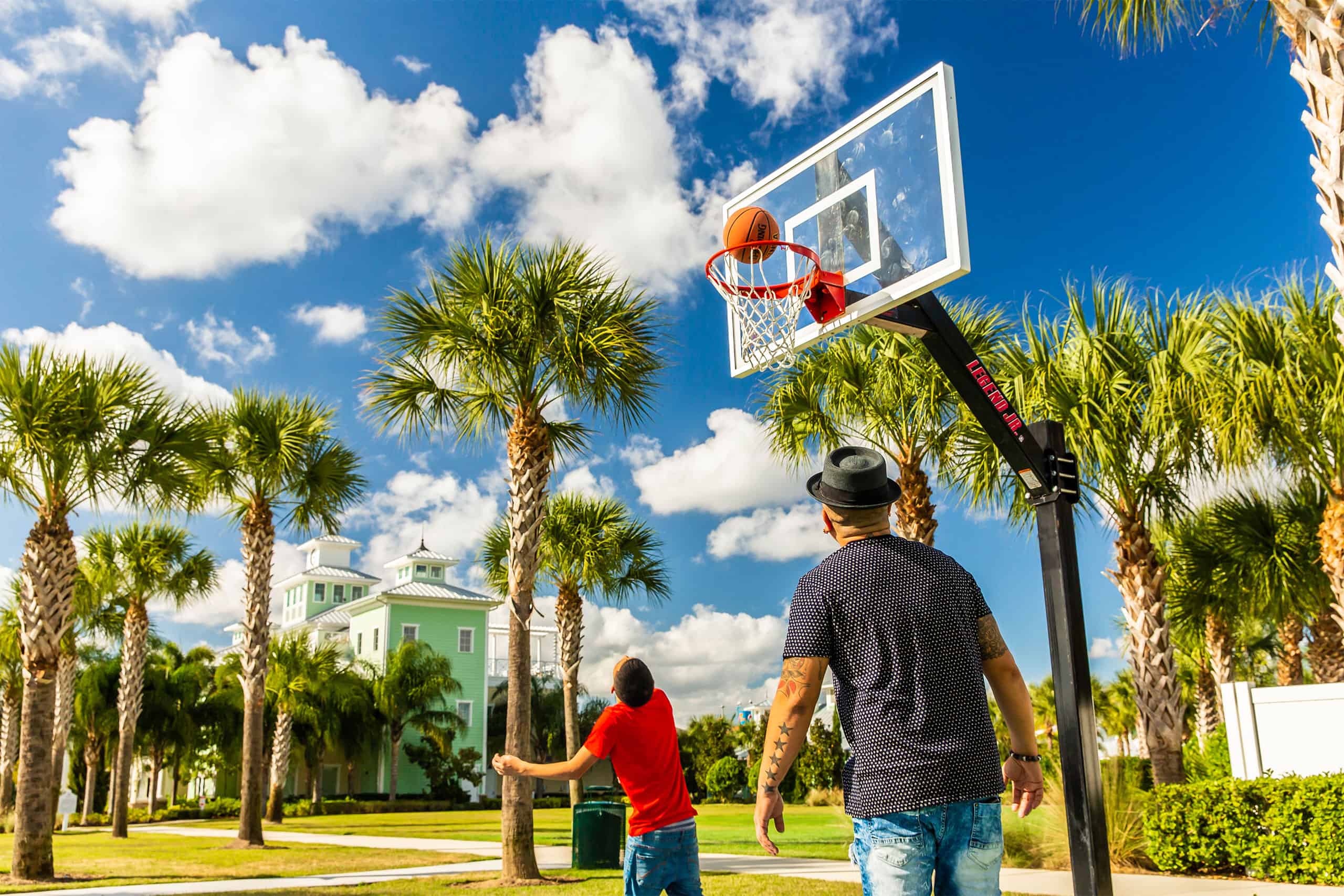 A father and son playing basketball on the Encore Resort East Side sports facilities.