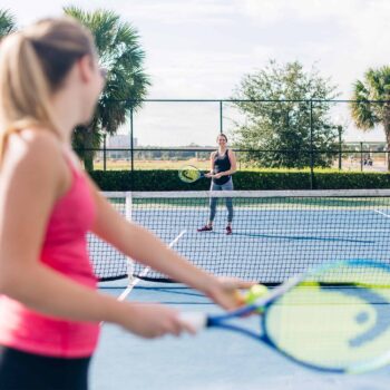 Women playing tennis on the Encore Resort East Side sports facilities.
