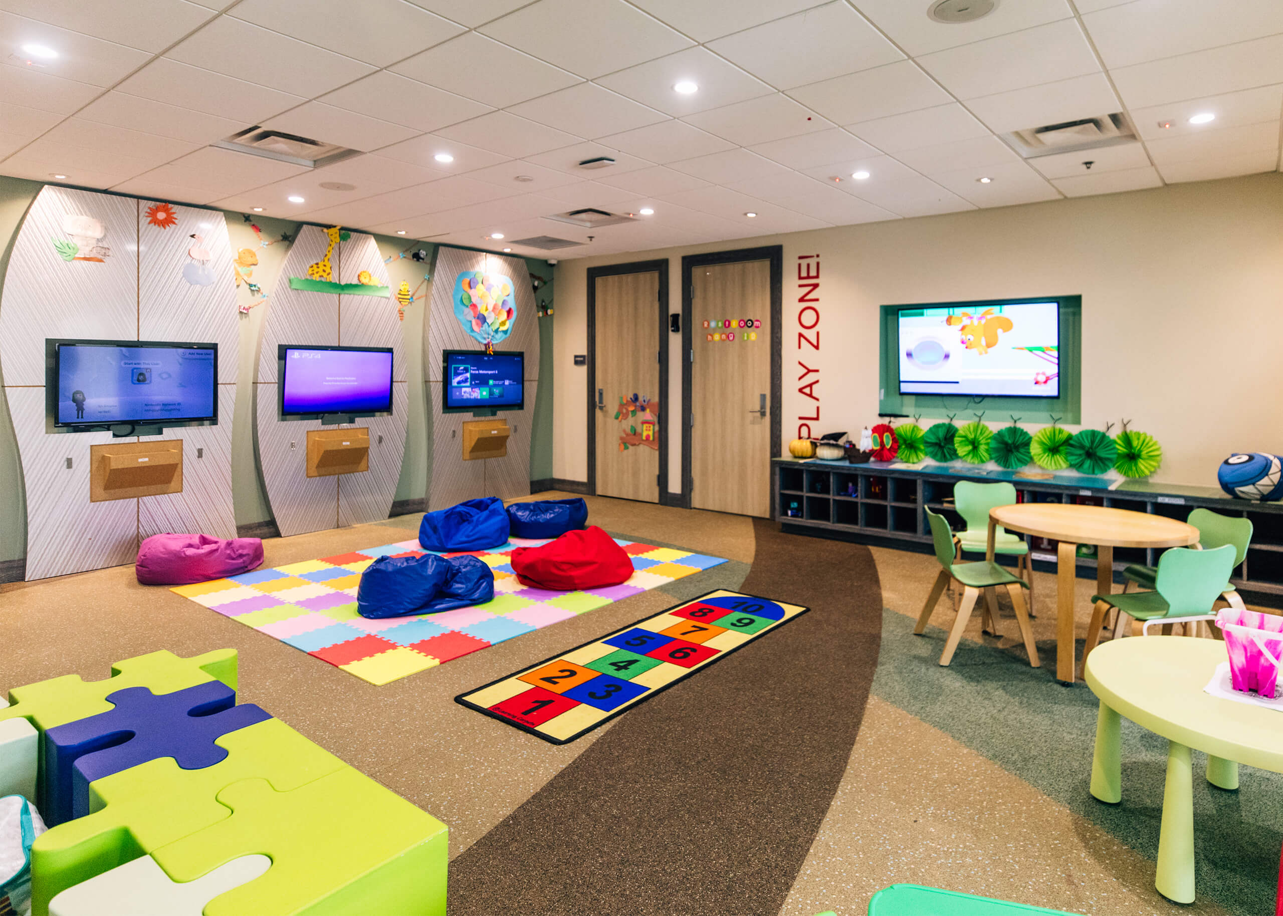 The Hang Ten Hideaway play room at Encore Resort, featuring bean bag chairs, video games, and toys.