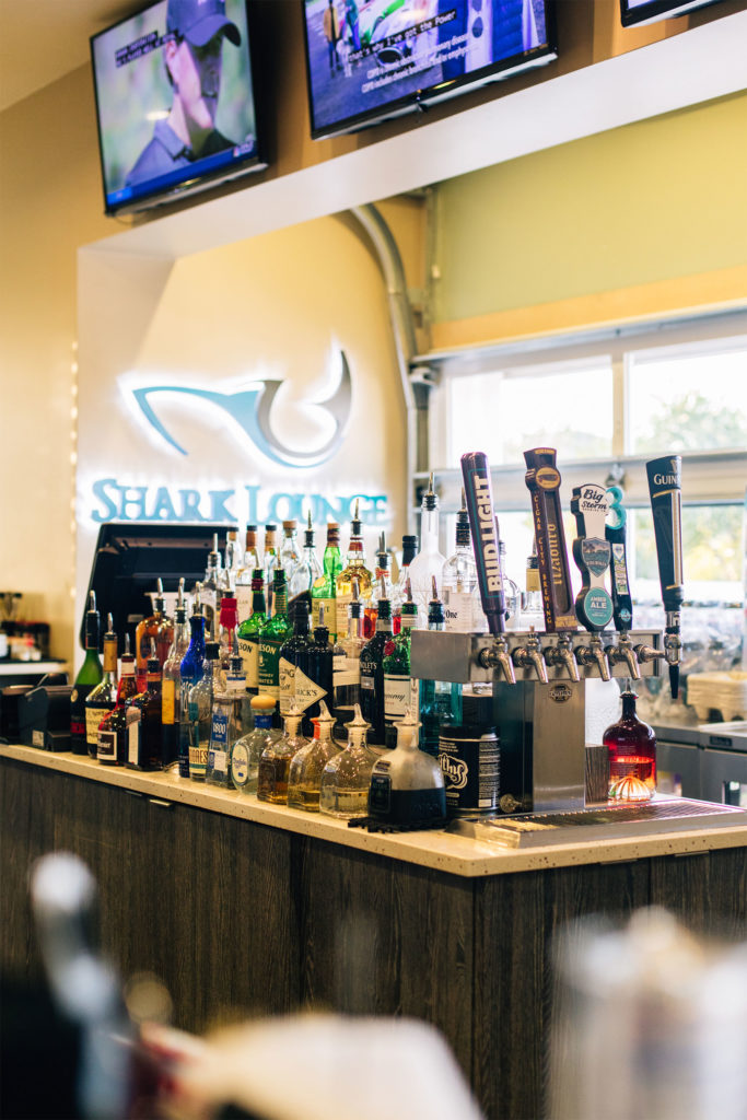 The Shark Lounge bar lined with bottles and taps of available drinks.