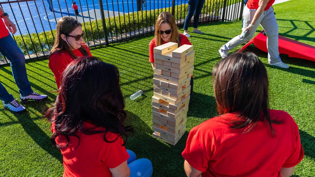 Grupo de mulheres jogando um jogo gigante de Jenga no gramado em Encore Resort na Reunião.