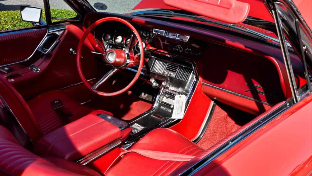 مقعد السائق الأحمر الساطع لسيارة كلاسيكية.