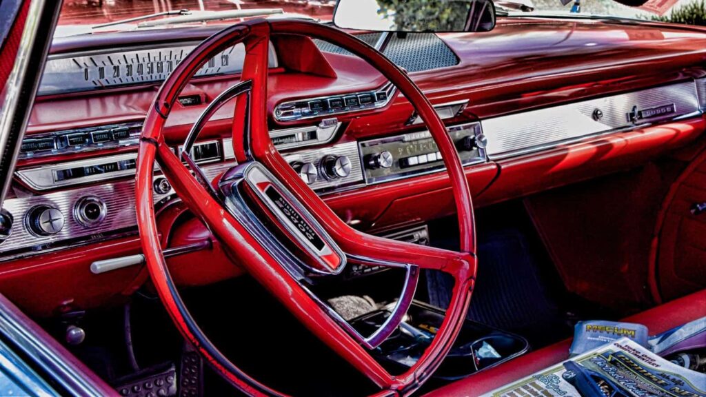 عجلة قيادة دودج كلاسيكية حمراء اللون ووحدة تحكم أمامية باللون الأحمر والكروم.