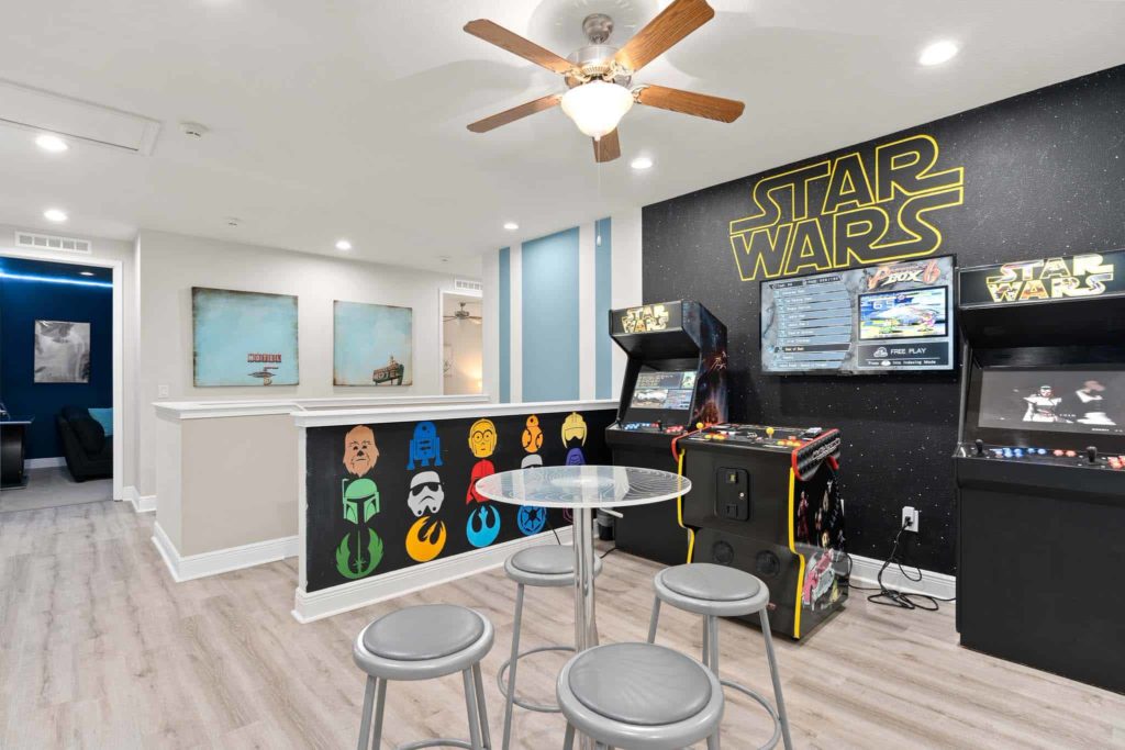 Upper-floor game room with arcade machines and Star Wars wall decor in Weathers’ Orlando vacation home.