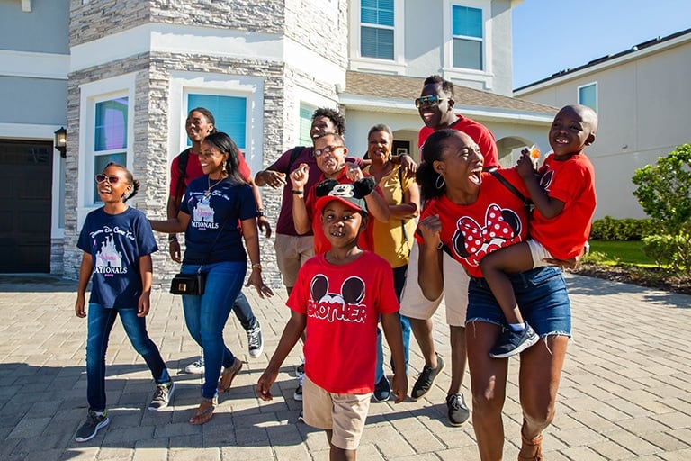 Una familia multigeneracional llega emocionada a su Encore Resort en la residencia del resort Reunion.