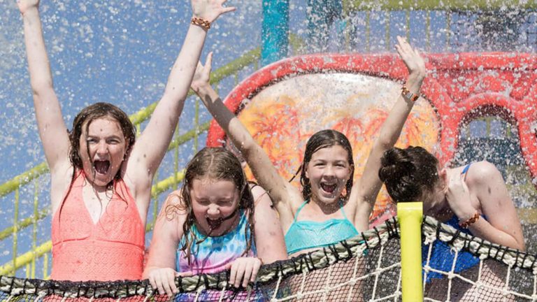 Girls splashing in the Surfing Safari Splash Zone at Encore’s Water Park.