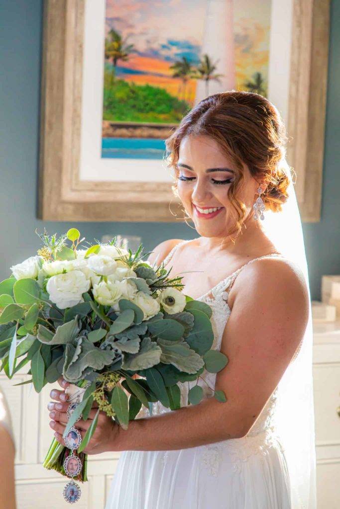 Braut lächelt mit ihrem Blumenstrauß in Encore Resort Clubhouse an ihrem Hochzeitstag