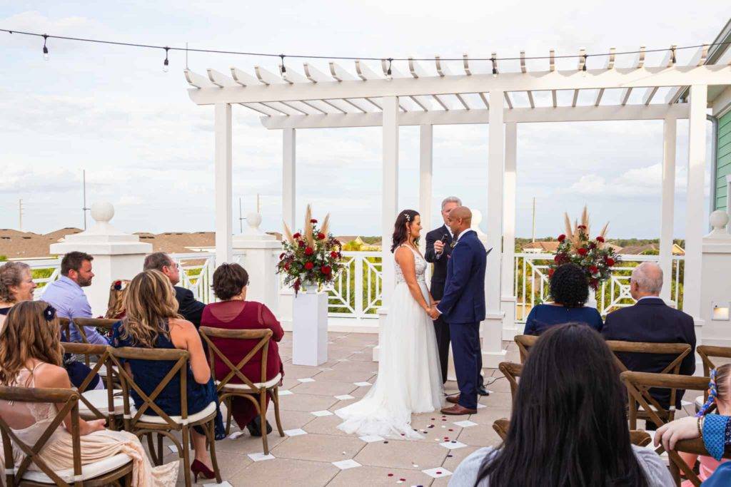 Bride and groom exchange vows during a wedding on the Encore Resort Clubhouse terrace