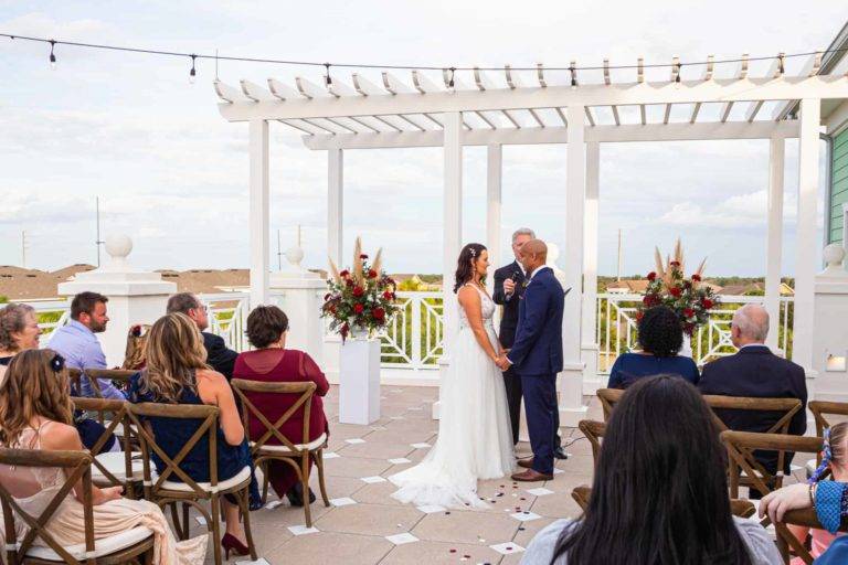 Les mariés échangent leurs vœux lors d'un mariage le Encore Terrasse du clubhouse du complexe