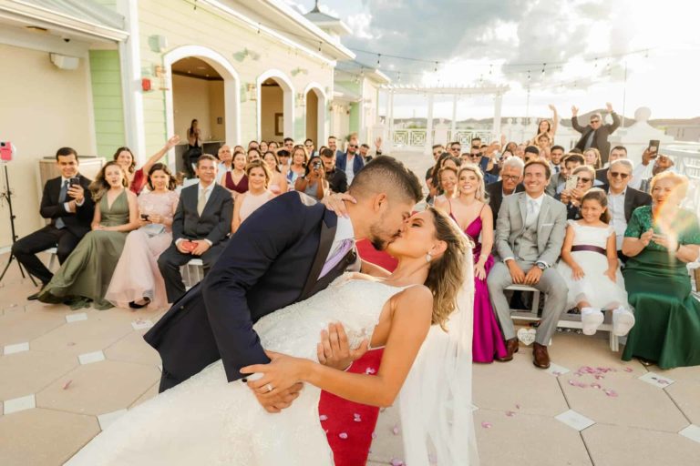 Le marié embrasse et trempe sa mariée lors d'un mariage sur le Encore Terrasse du complexe
