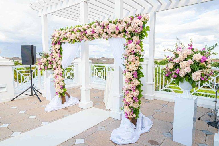 Encore Terrasse du Resort Clubhouse décorée pour une cérémonie de mariage avec une arche fleurie