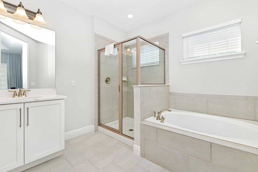 Hauptbadezimmer mit Doppelwaschbecken, Dusche mit Glastür und separater Badewanne