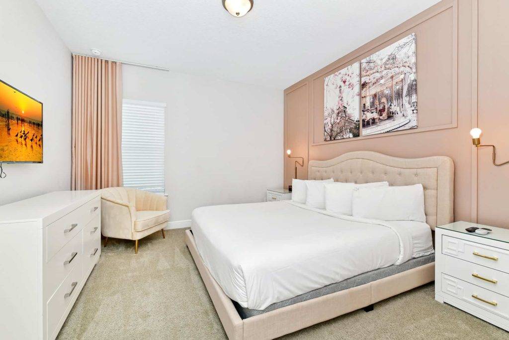 Bedroom 4 with king bed, armchair, dresser, and TV