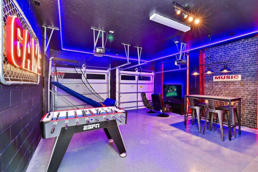 Arcade basketball, foosball, and gaming station in themed game room