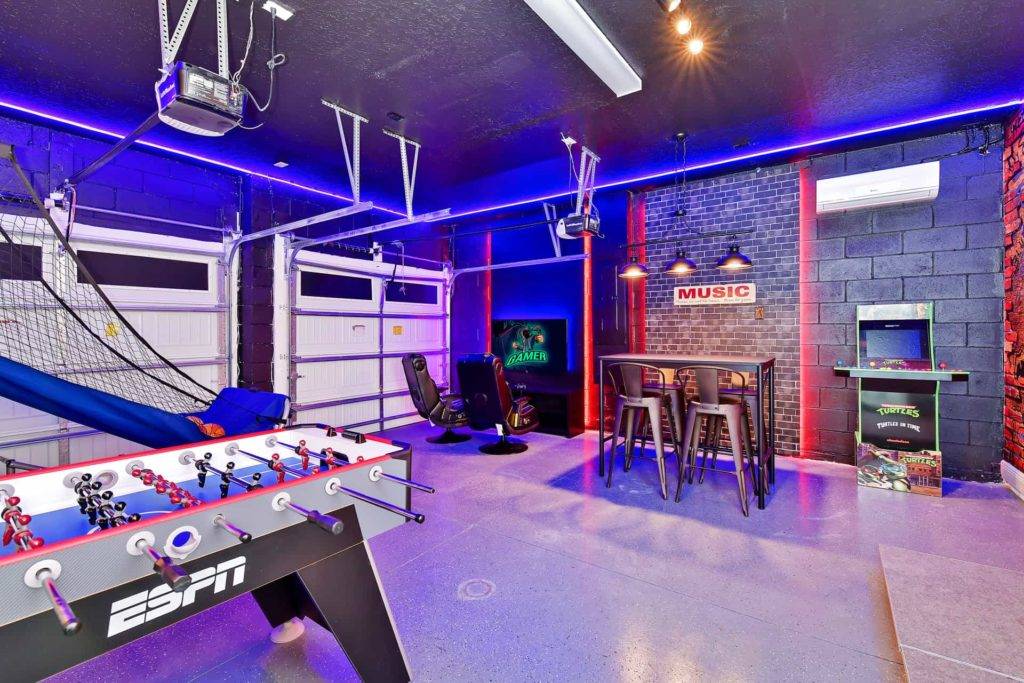 Home garage converted into a game room with Foosball table, arcade cabinets, and arcade basketball game