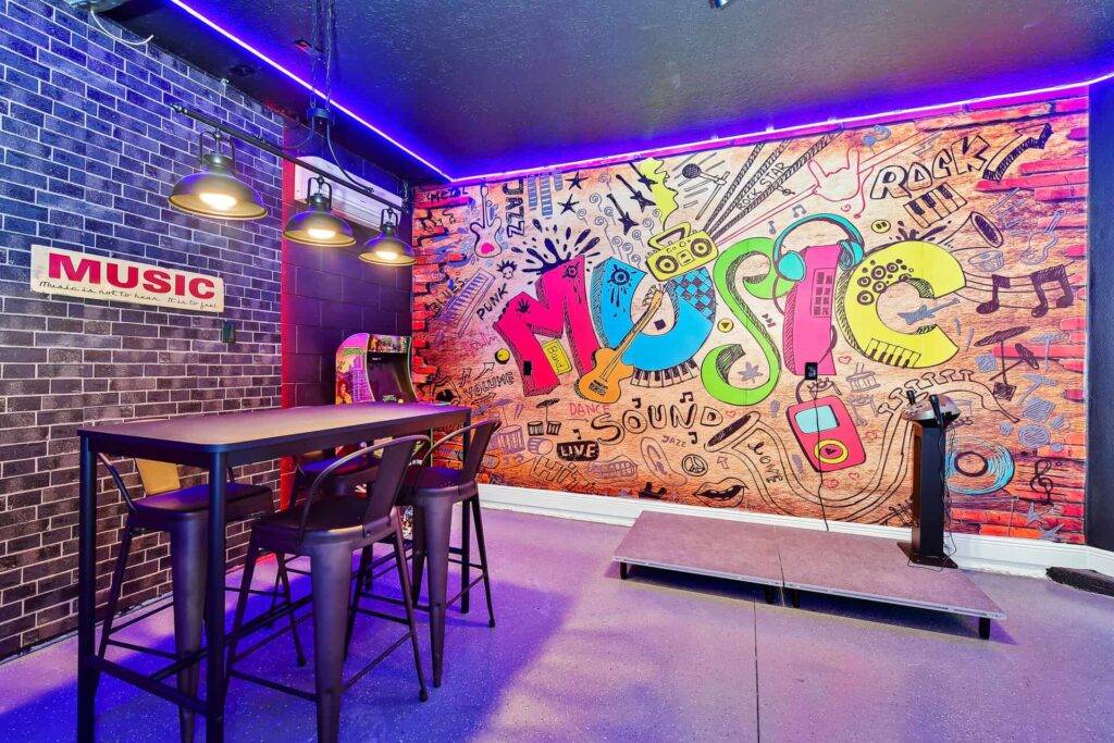 Colorful music-themed mural with karaoke machine in themed game room