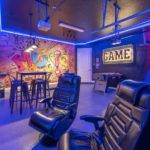 Themed game room with Music wall art, arcade basketball, and gaming station