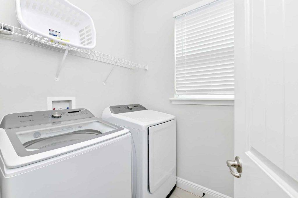 Laundry room with washer, dryer, and laundry basket