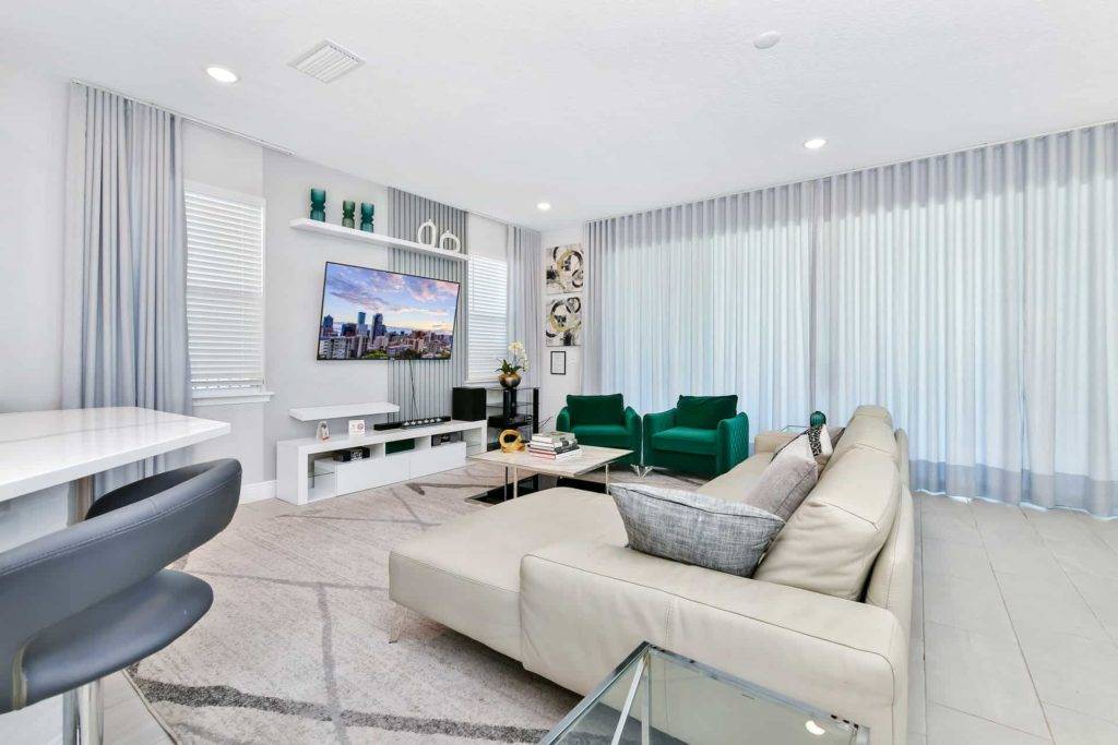 Living room with sectional sofa, armchairs, and wall-mounted TV