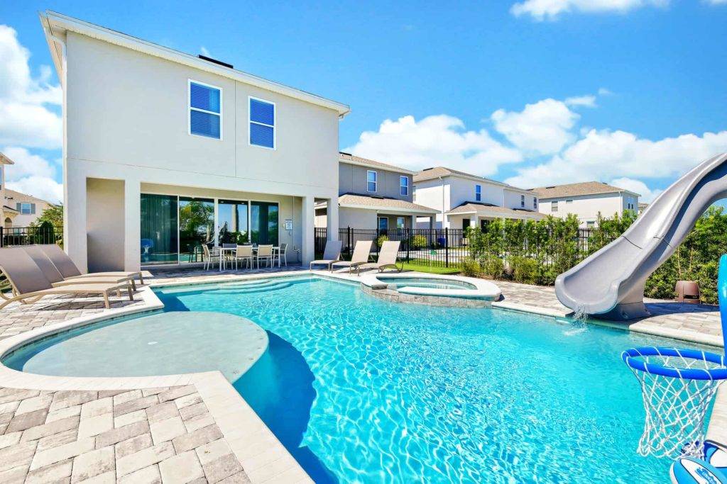 Private backyard with pool, hot tub, covered lanai, and slide