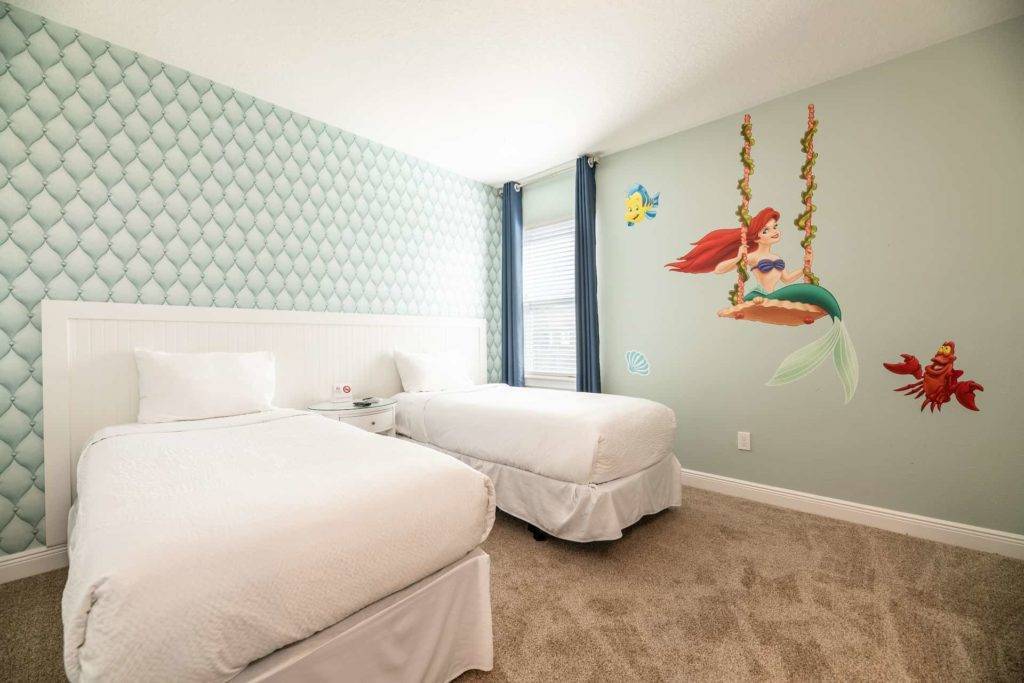 Kids’ bedroom decorated with art from Disney’s The Little Mermaid, with double twin beds