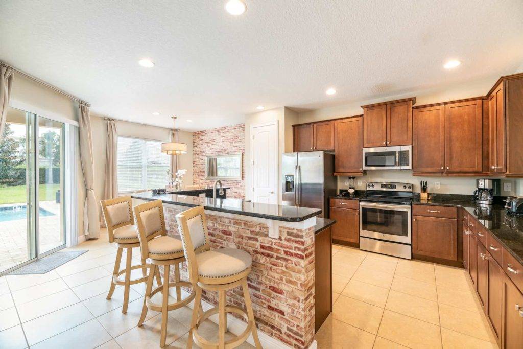 Fully equipped kitchen with brick island and barstool seating