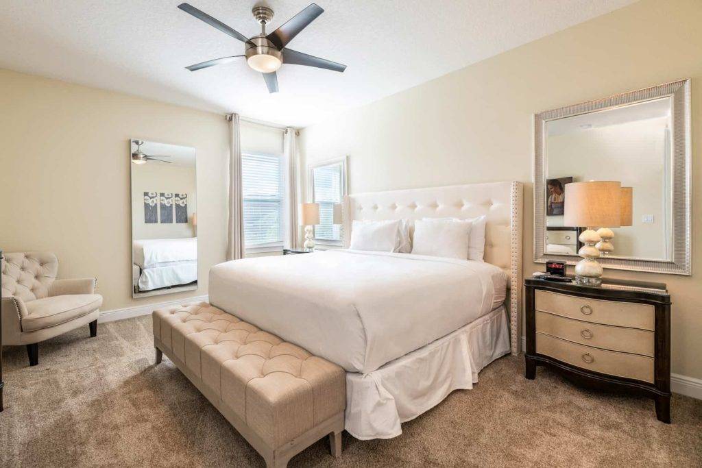 Master bedroom with large king bed and ottoman