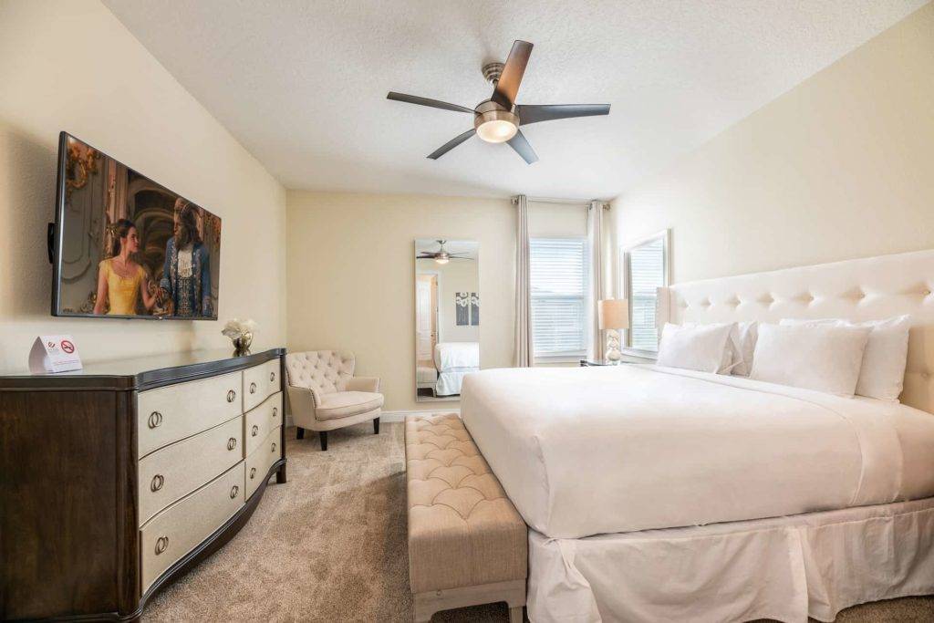 Master bedroom with large king bed and wall mounted TV