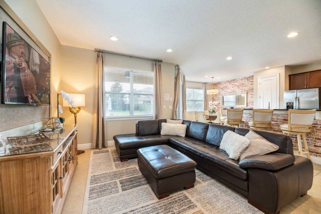 Living and dining room with sectional sofa, ottoman, and dining room