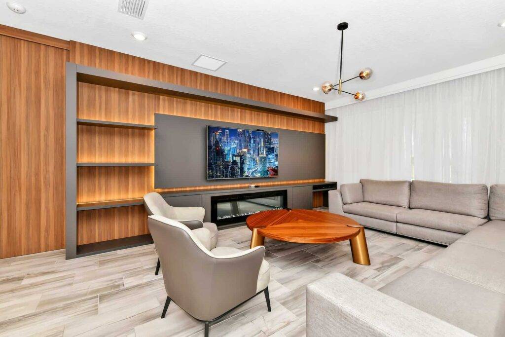 Wohnzimmer mit Sofagarnituren, Sessel, Couchtisch und wandmontiertem Fernseher
