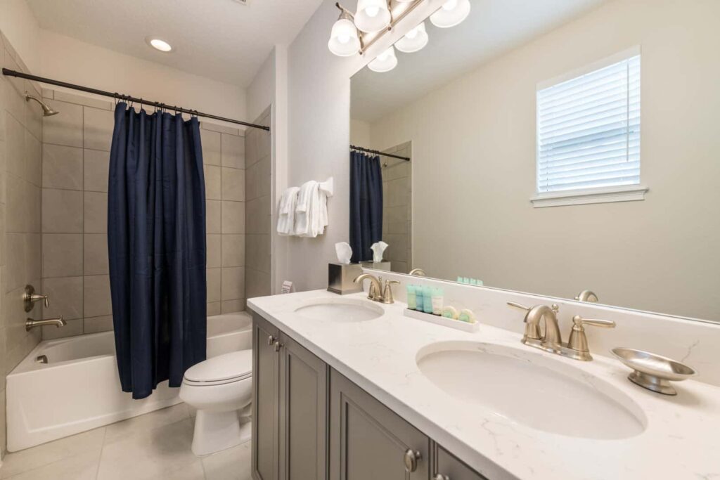 Badezimmer mit Doppelwaschbecken und kombinierter Badewanne und Dusche: Ferienhaus mit 10 Schlafzimmern