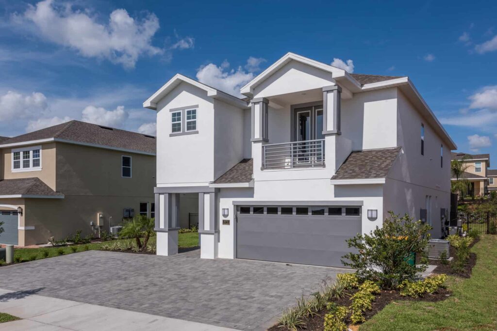 6 bedroom home exterior front with private driveway parking and covered balcony