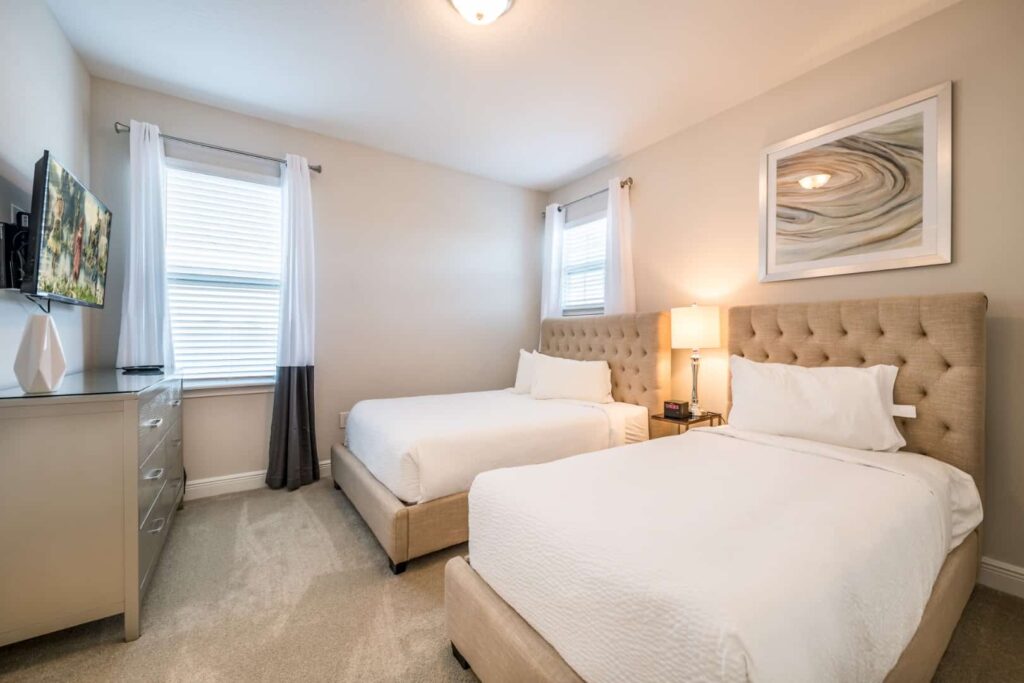 غرفة نوم مع سريرين مزدوجين وخزانة ملابس وتلفاز مثبت على الحائط: 5 غرف نوم للعطلات