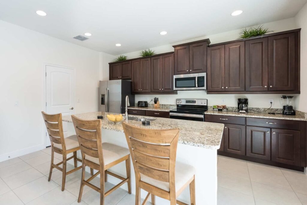 Full kitchen with island counter, barstool seating, refrigerator, and microwave: 5 Bedroom Vacation Home
