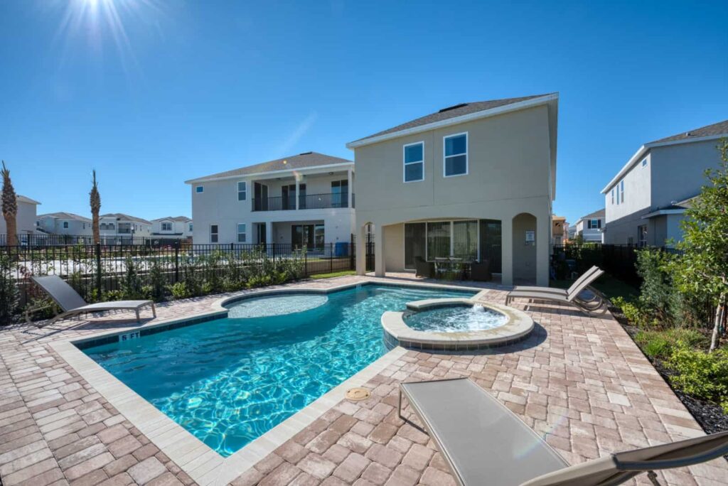 Private backyard with pool, hot tub, sun loungers, and covered lanai: 6 Bedroom Vacation Home