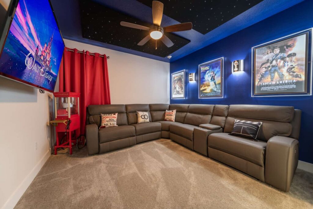 صالة وسائط مع أريكة مقطعية وملصقات أفلام مؤطرة وتلفزيون معلق على الحائط: 7 Bedroom Vacation Home