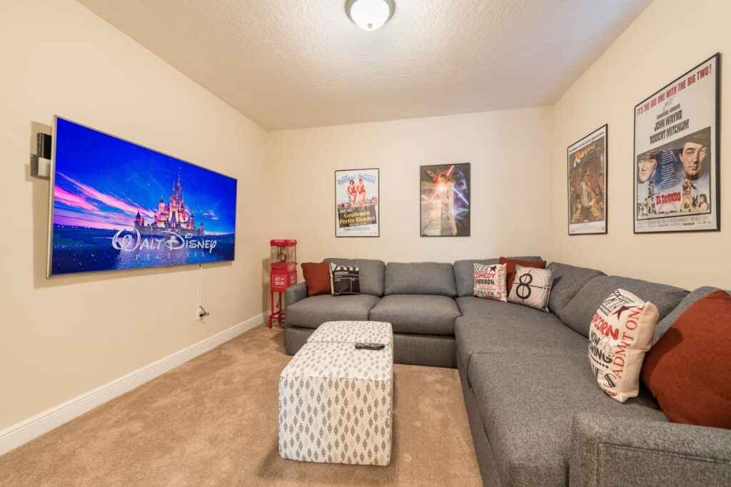 صالة وسائط مع أريكة مقطعية وعثماني وتلفزيون معلق على الحائط: 7 Bedroom Vacation Home