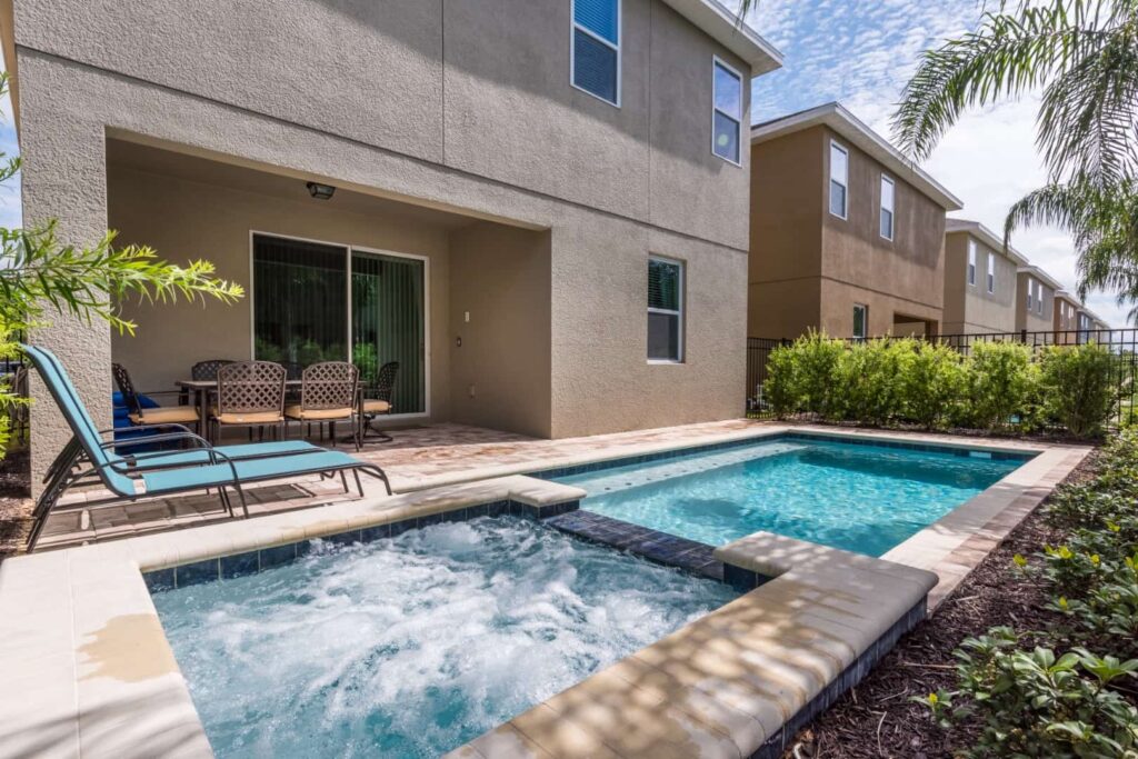 Private backyard highlighting pool, hot tub, and covered lanai: 8 Bedroom Vacation Home