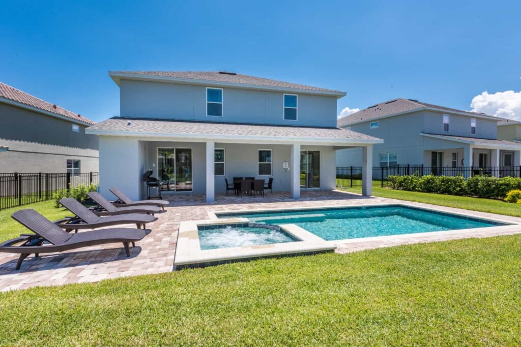 Private backyard with pool, hot tub, sun loungers, and covered lanai: 8 Bedroom Vacation Home