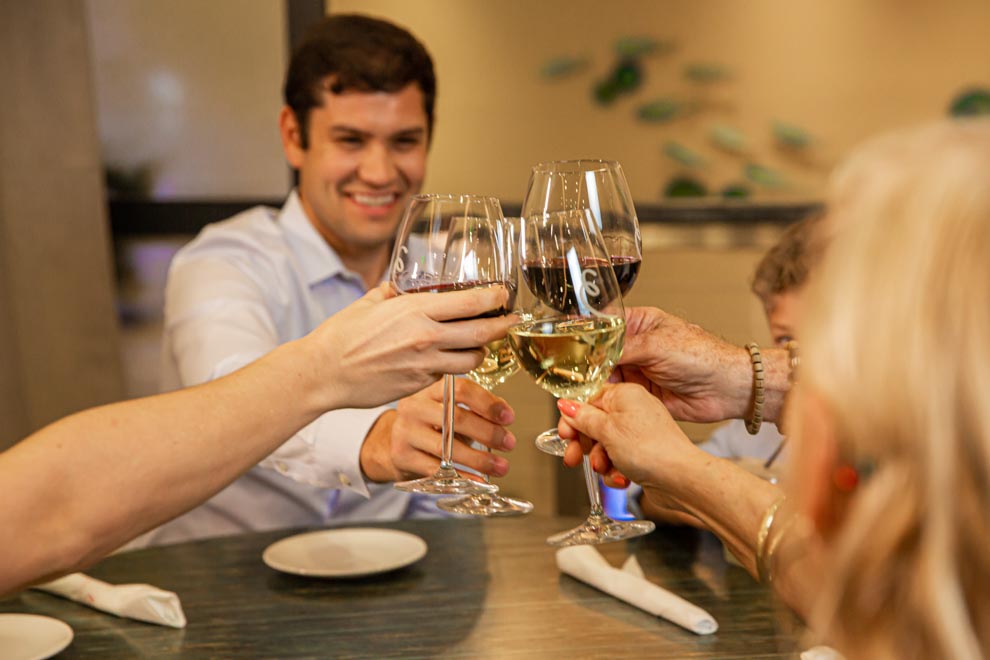 Familie stößt mit Wein an Encore Resort at Reunion kuratierte Resortresidenz.