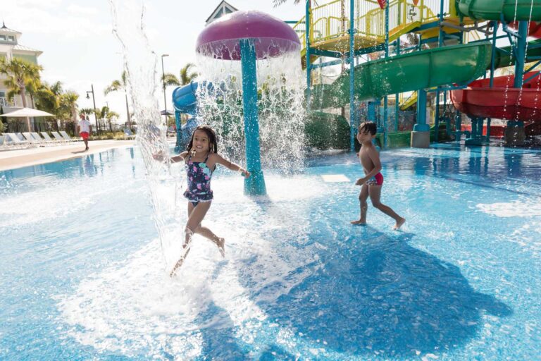 Дети веселятся под грибным фонтаном в бассейне в Encore Курортный аквапарк.