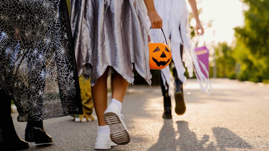 Gruppe von Kindern in Kostümen Süßes oder Saures für Halloween