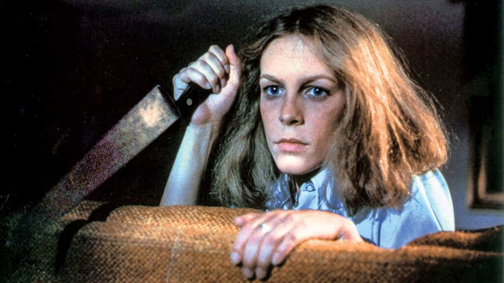 Jamie Lee Curtis hält im Halloween-Film von 1978 ein Messer