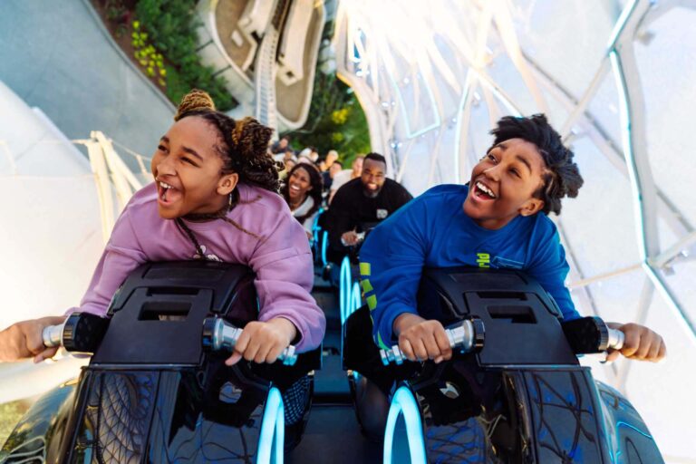 Siblings riding the Tron roller coaster at the Magic Kingdom